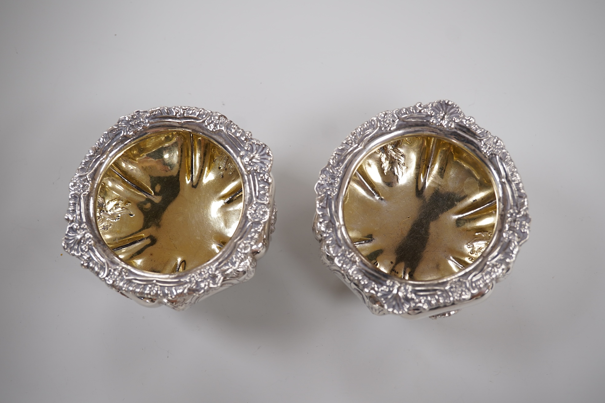 A pair of early Victorian silver cauldron salts, by John Tapley, London, 1838, with later blue glass liners, diameter 94mm, together with a pair of George IV silver Old English pattern condiment spoons, London, 1828.